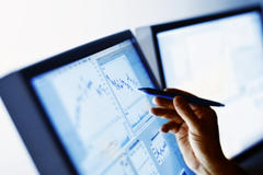 Hand pointing to digital stock market chart
