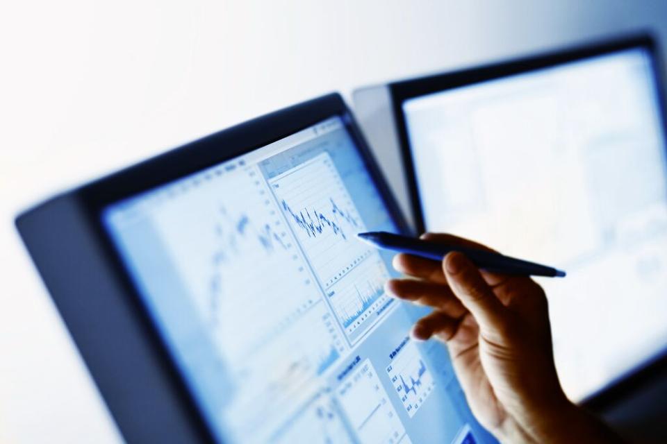 Hand pointing to stock market chart