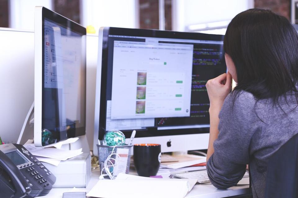 woman sitting at computer, view from behind